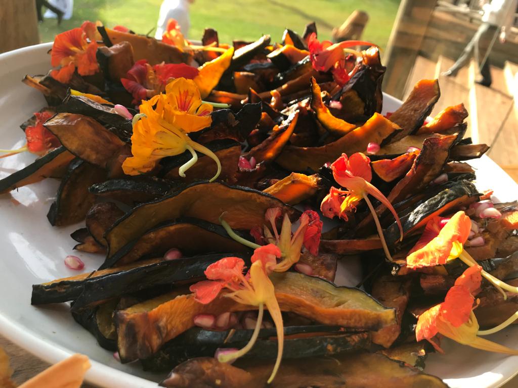mesa com snacks de lascas de abóbora cabotiá e sementes de romã